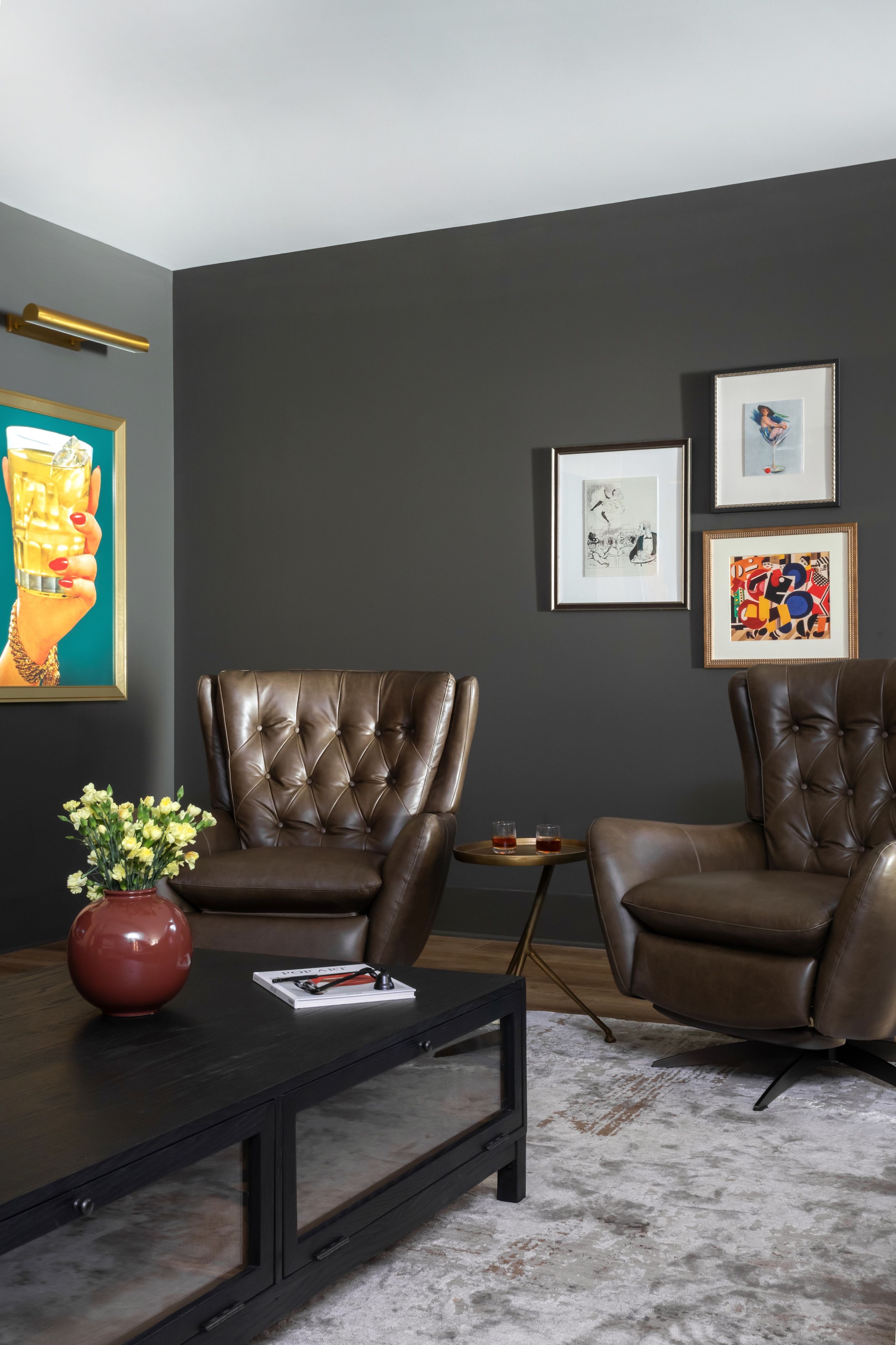 Sitting room featuring classic leather furniture, colorful contemporary artwork, and neutral finishes.